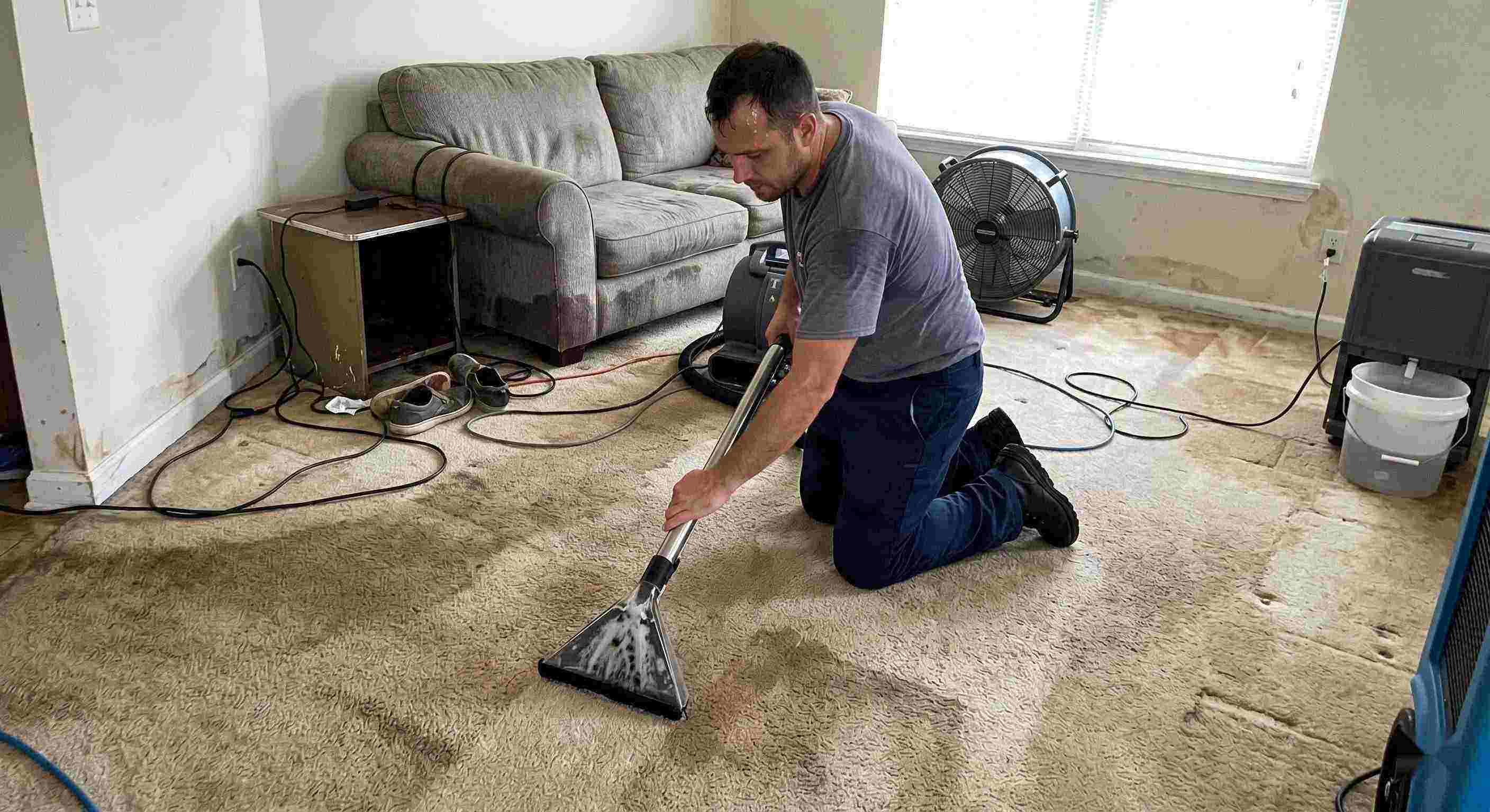 Expert technician performing carpet water extraction in a residential home using professional equipment after water damage in Dearborn