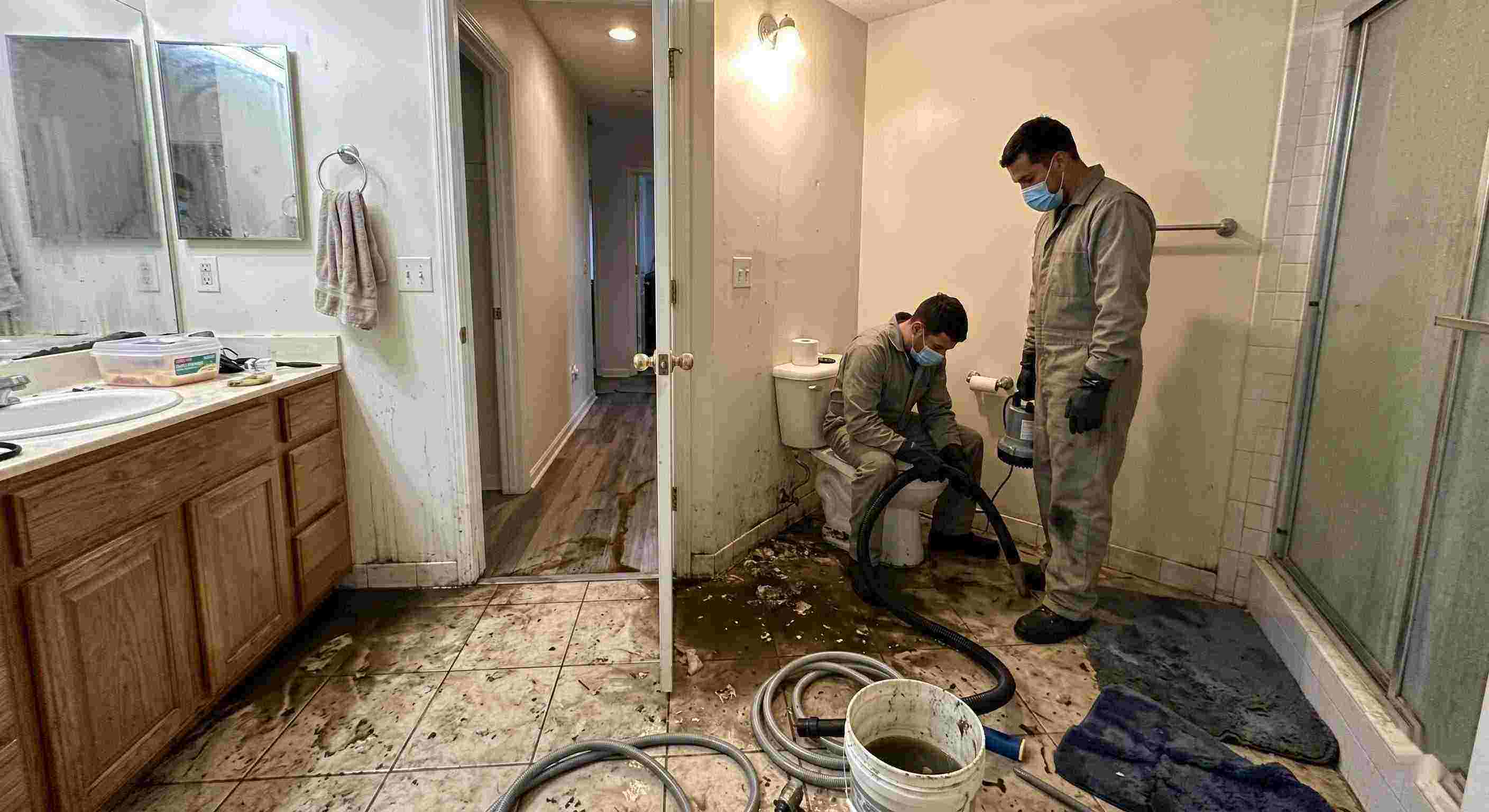 Septic tank backup cleanup in Ann Arbor bathroom with technicians removing contaminated water and sanitizing affected areas